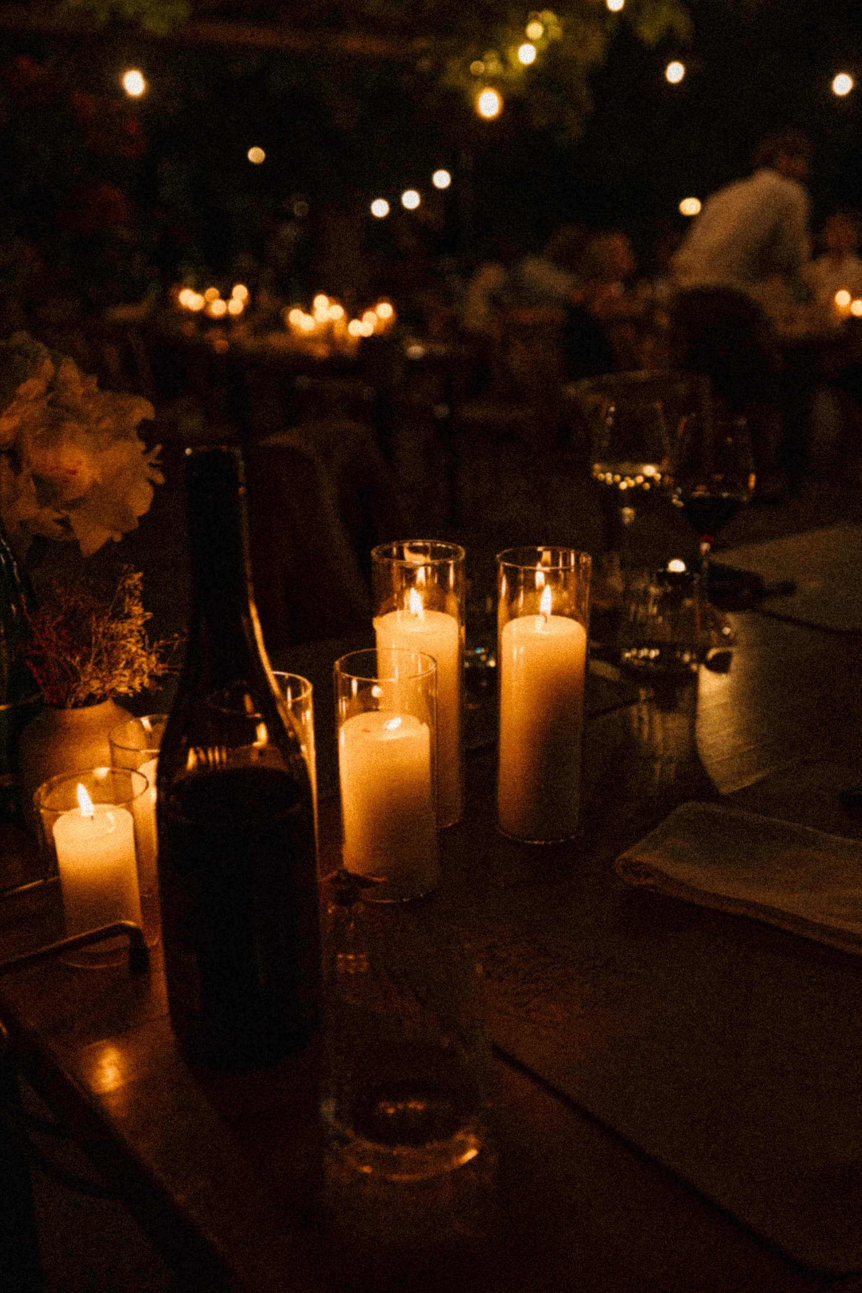 Candlelit dinner tables glowing at dusk