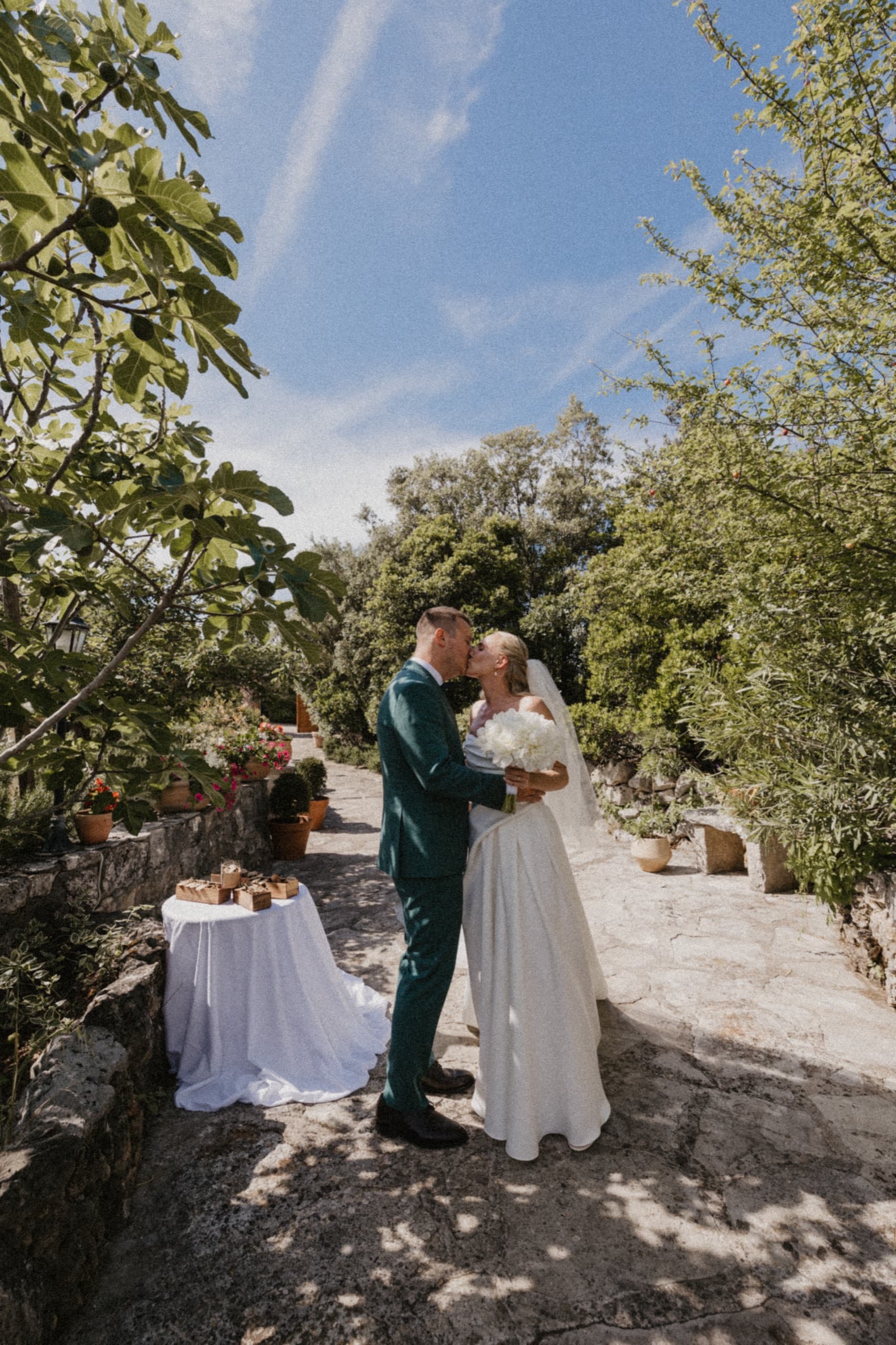 Bride and groom on a stone path at the olive-grove venue