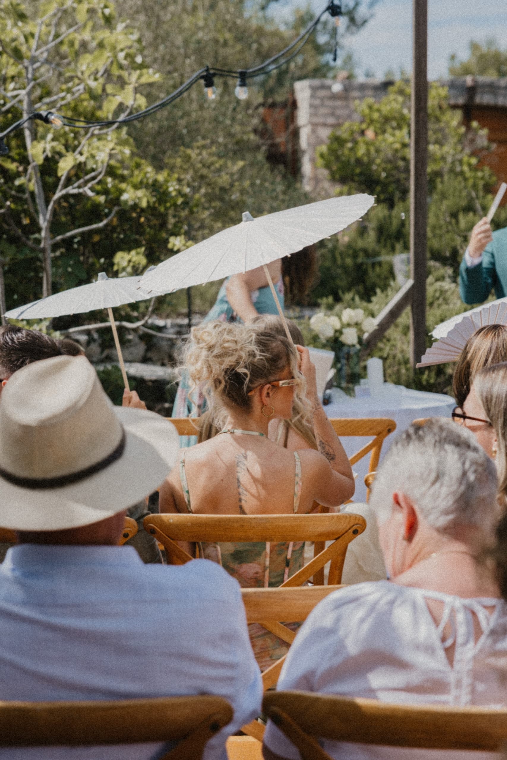 Guests relaxing under a white parasol in the summer heat